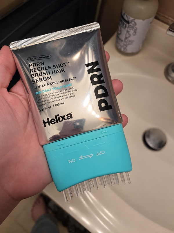 Customer holding Helixa scalp serum